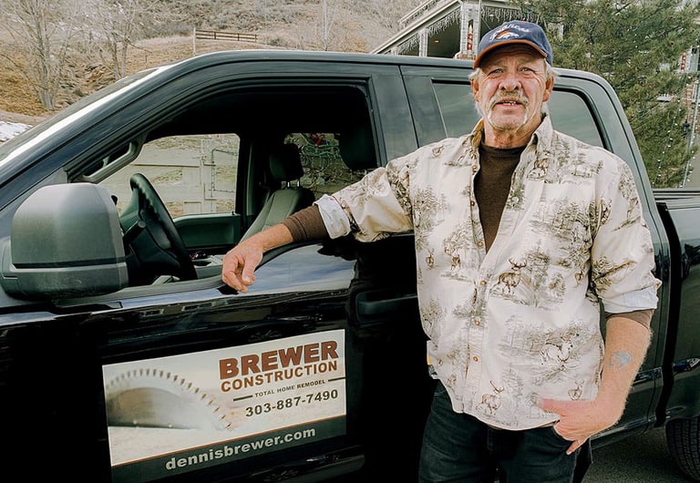 Dennis Brewer, master carpenter and owner of Brewer Construction, standing by his company truck in Golden, Colorado.