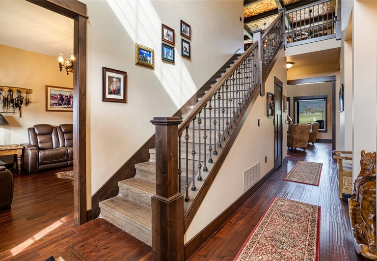 Custom wood flooring and stair rail in a luxury home built by Saddle Horn Custom Homes