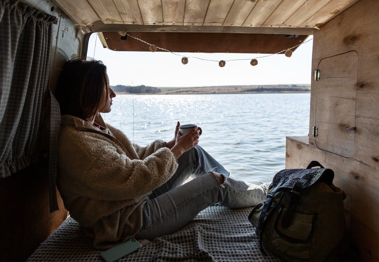 Girl enyoing the sea at the back of campervan
