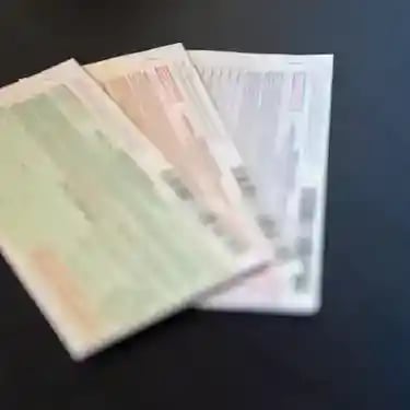 Three bail bonds in green, pink, and blue spread out on a desk in Idaho.