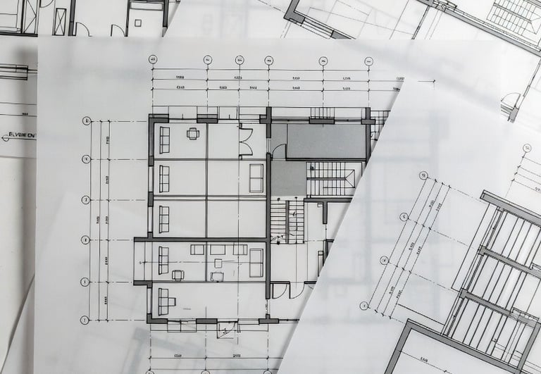 Detailed architectural blueprints and floor plans printed on semi-transparent vellum paper for home construction.