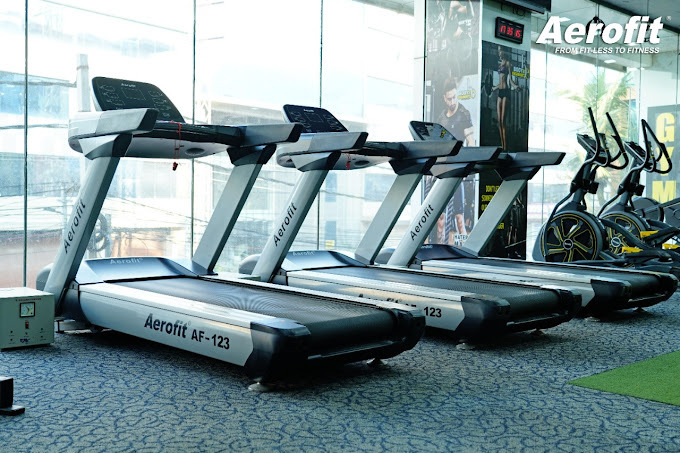 a gym room with tread treads and a treadmill