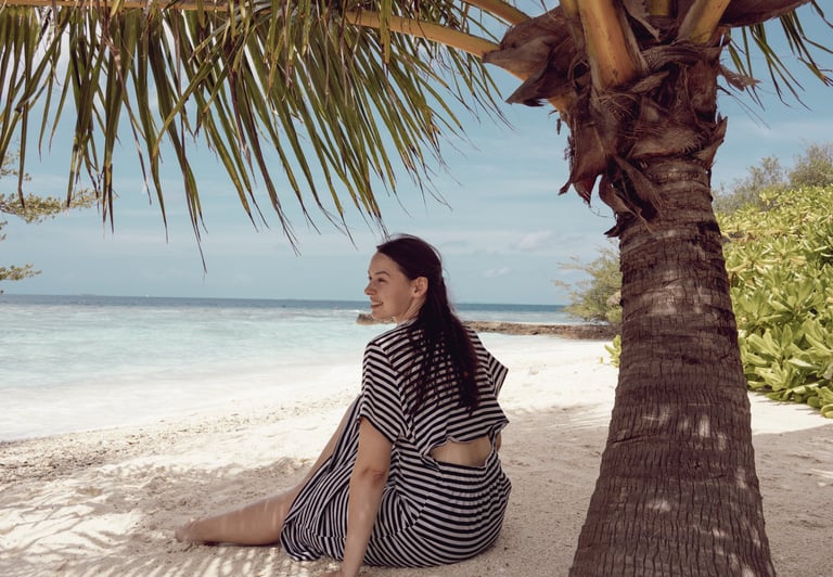 Reisefotografie Malediven: Jana von Lebensmomente fotografiertgenießt einen Moment am Strand.