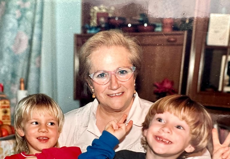a woman in glasses and a child's hand holding a camera