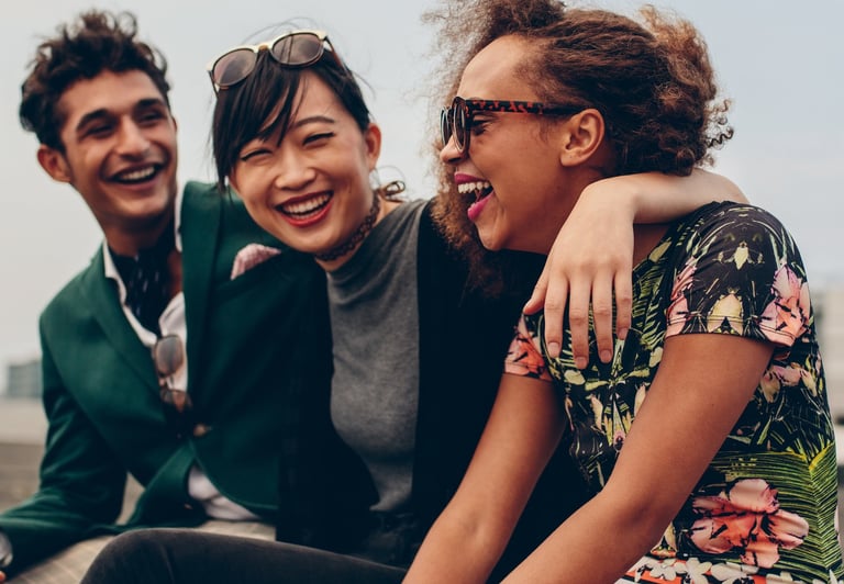Three friends laughing. One of them is struggling with high functioning anxiety and masking symptoms