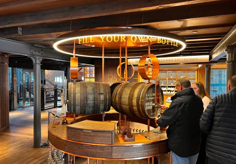a man and woman standing in front of a barrel of whisky