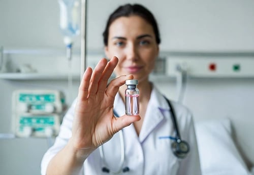 Female doctor in a hospital holding a medical vial of stem cells