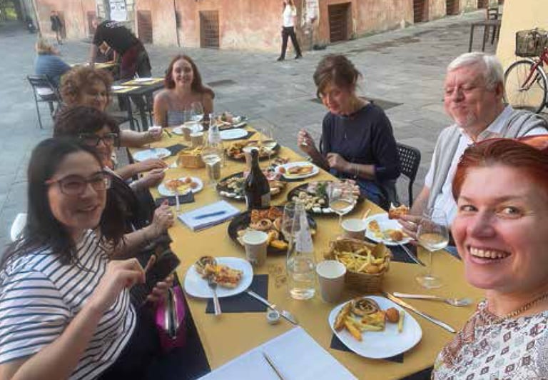 a group of people sitting at a table with food