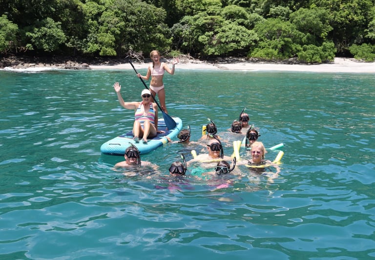 Family enjoying snorkeling and paddle boards in turquoise waters during catamaran tour Papagayo