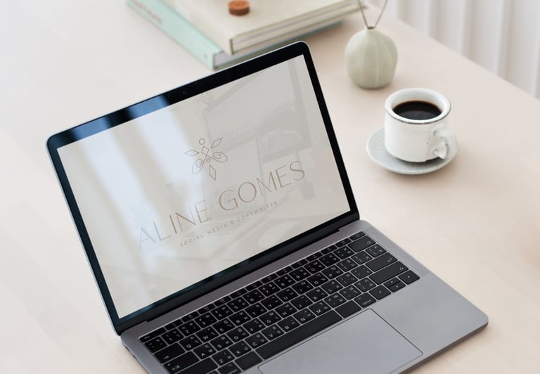 Uma tela de laptop exibindo uma wallpaper com a logo criada. Uma xícara de café está na mesa ao lado