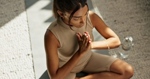 a woman in a tan dress is sitting on a bench