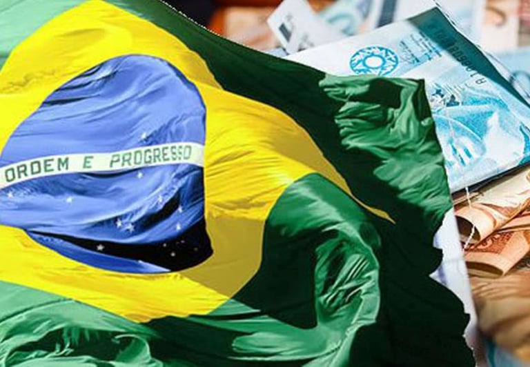imagem mostra a bandeira do brasil e várias notas de dinheiro em volta