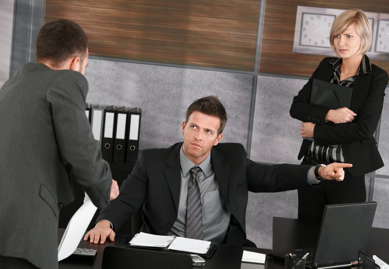 a man and woman in business attire sitting at a desk
