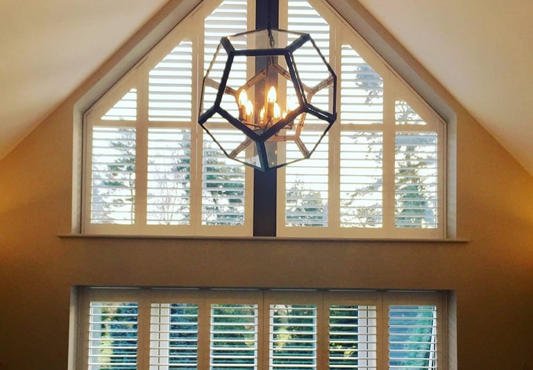 picture of internal hardwood shutters in a shaped window