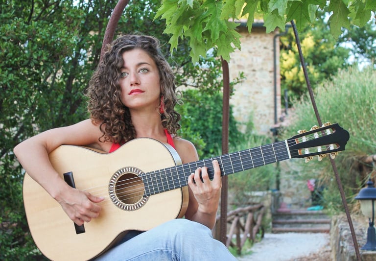 a woman with curly hair and a guitar
