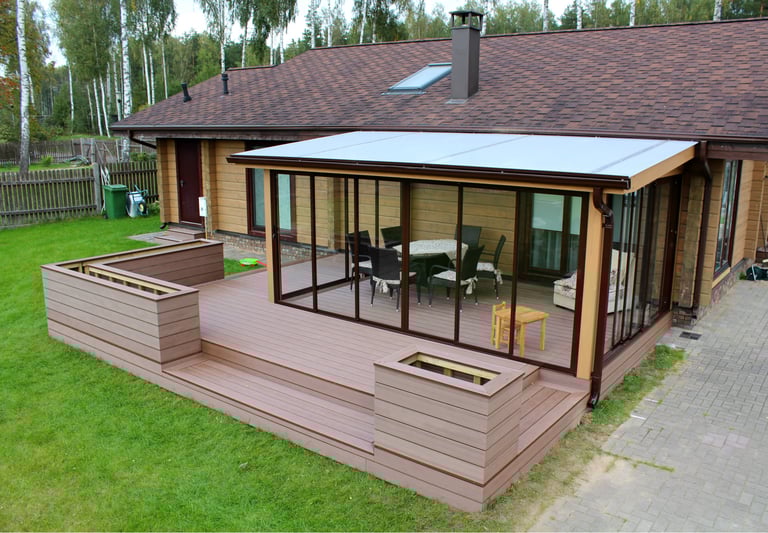 Modern wooden house with a glass-enclosed patio, composite decking, and outdoor furniture.