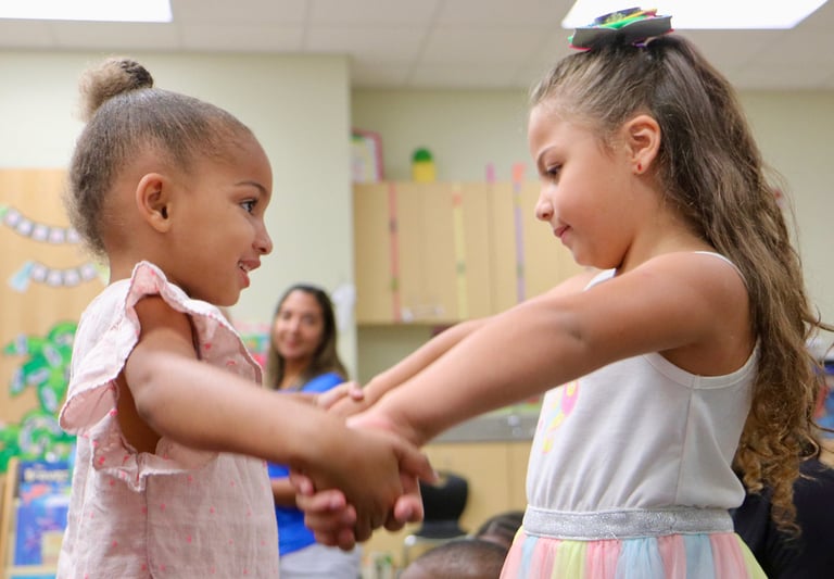 young girls holding hands and moving
