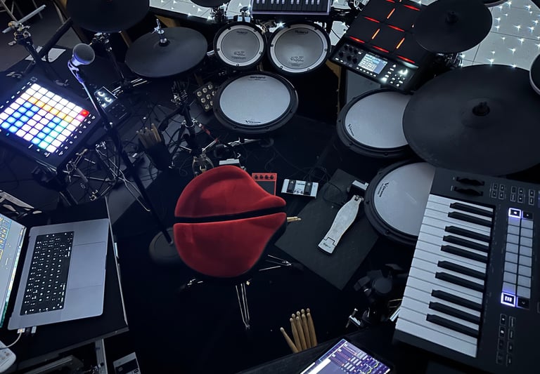 a drum set up with a laptop and keyboard