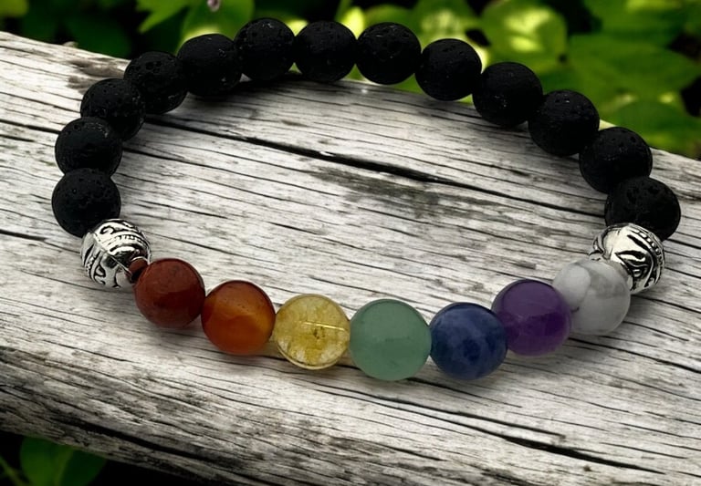 A bracelet with mostly black beads & seven rainbow beads to represent the chakras and silver accent