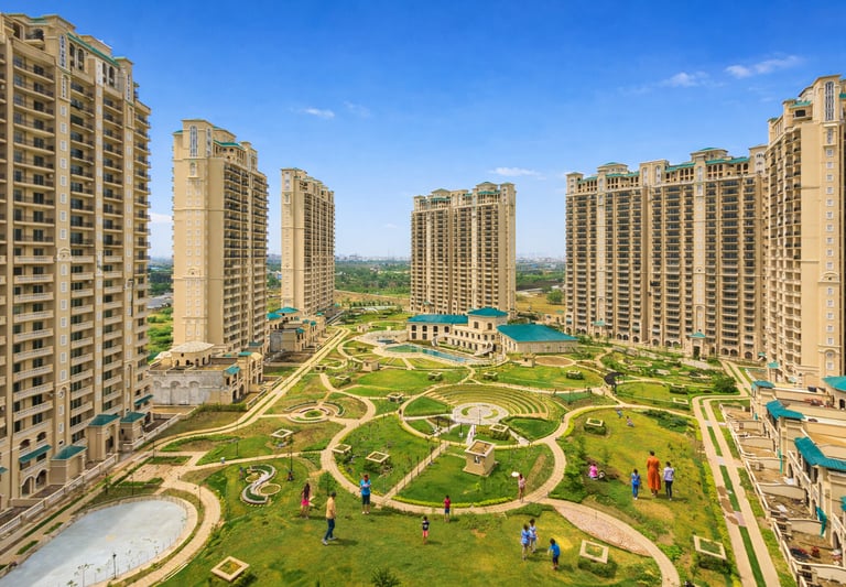 Luxury residential high-rise apartment complex featuring a landscaped courtyard with walking paths and green spaces.