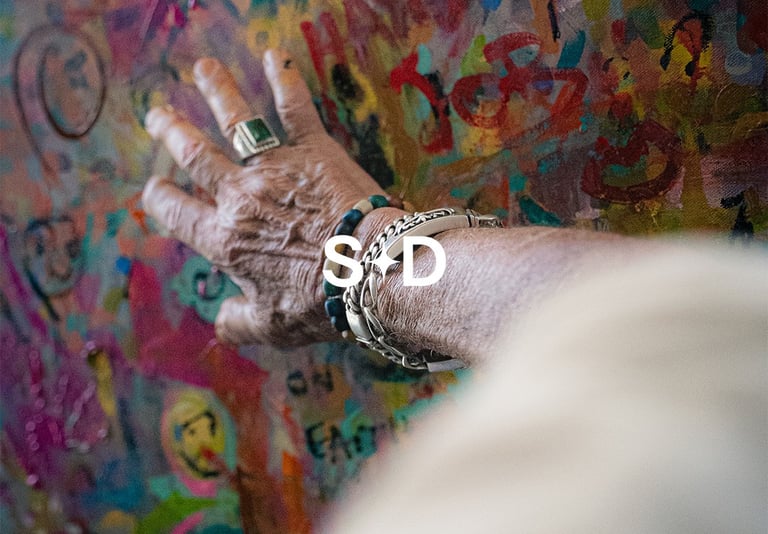 Artist Stevendick.art hand on colorful painting for BrandNests branding and social strategy.