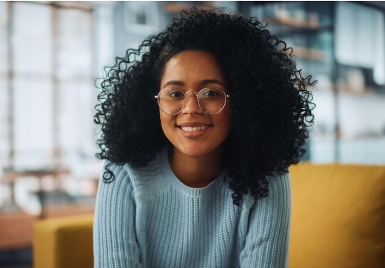 a woman with glasses and a blue sweater