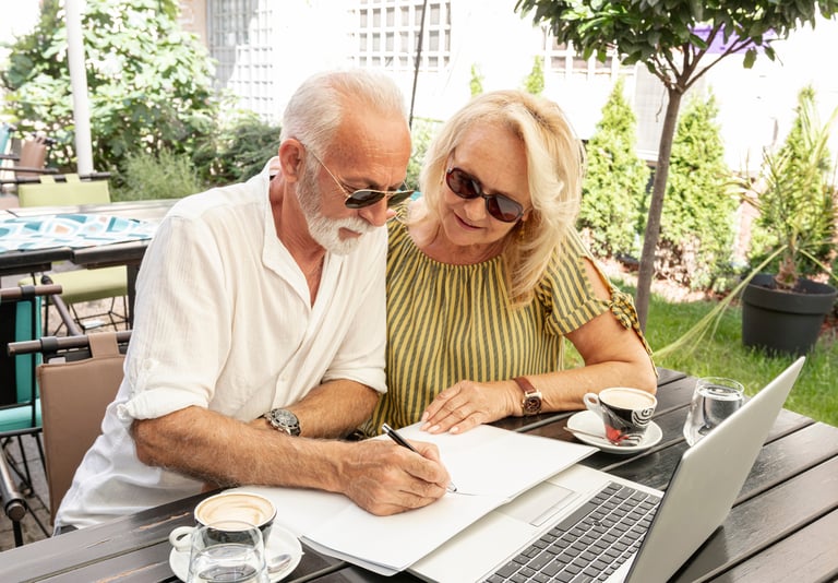 a man and woman sitting at a table with a laptop