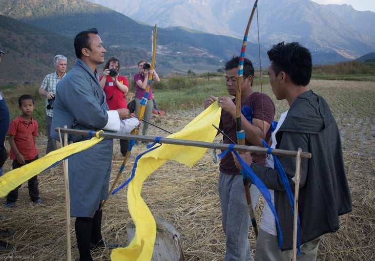 drukyul-delights-ceo-putting-demo-on-traditional-archery-to-his-group-getting-photographs