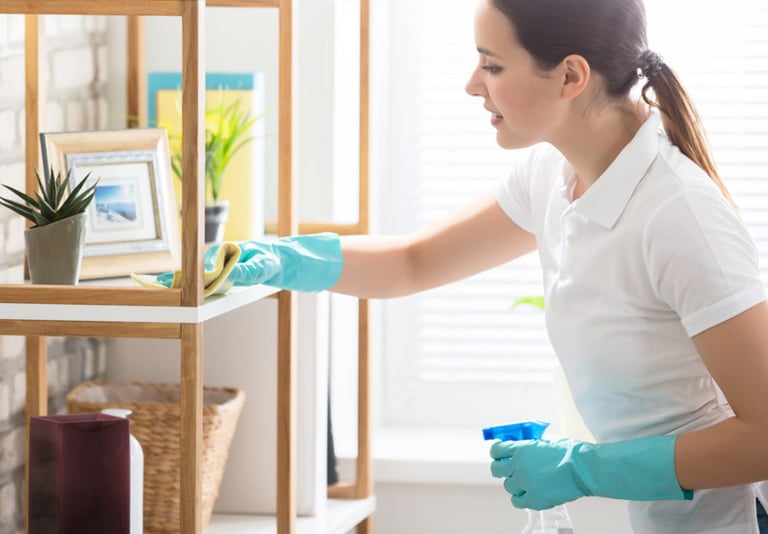 a house cleaner in a white shirt and gloves cleaning in Laguna Beach