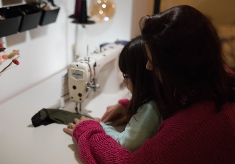 une femme et une petite fille sont en train de coudre un sac banane