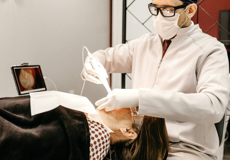 a dentist performimg dental cleaning procedure for a patient lying down