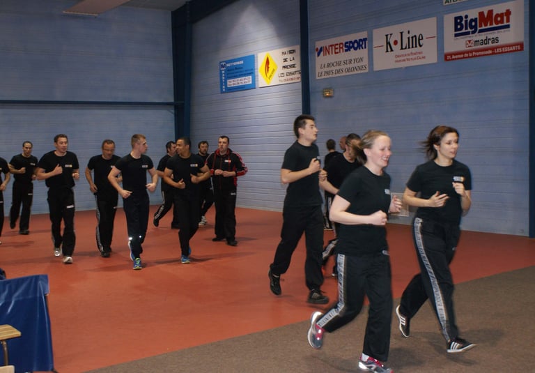 a group of people in black shirts and black pants, running and practice krav maga