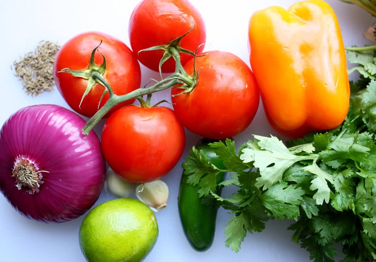 salsa ingredients, tomatoes, cilantro, peppers, limes, garlic and cumin seeds