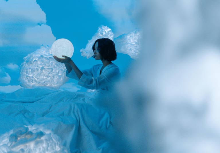 une femme en robe blanche assise sur un nuage pour l'Alliance de la sophrologie et de l'analyse