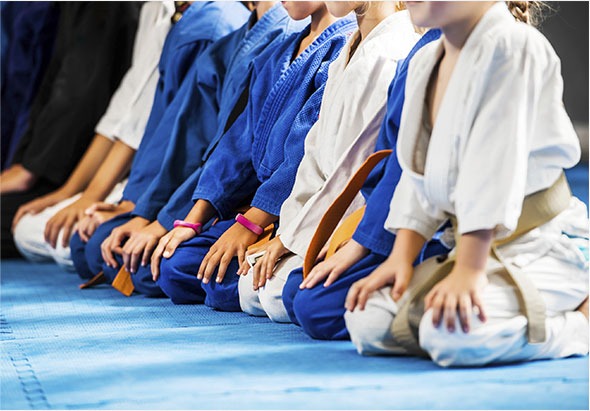 Jeunes judokas à genoux au salut