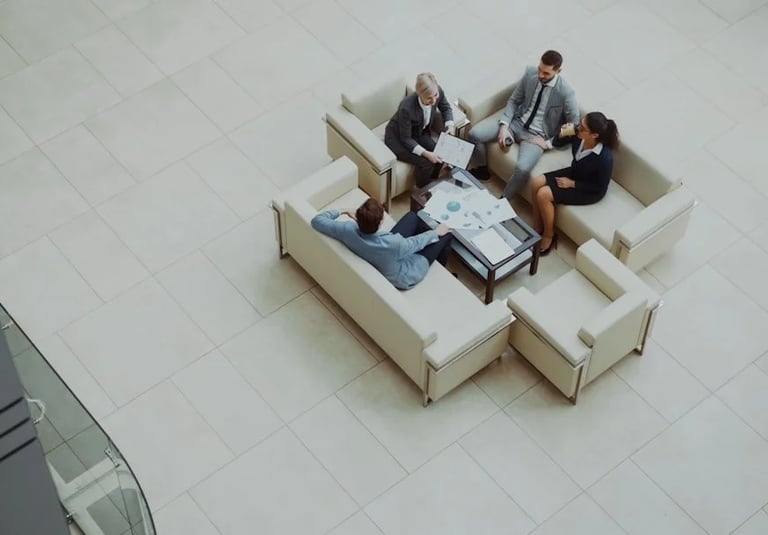 High angle view of diverse business colleagues in a formal meeting discussing data charts in a modern office lobby.
