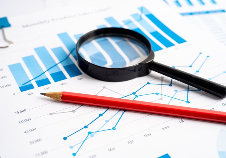 a red pencil and a magnifier on a desk identifying for profits