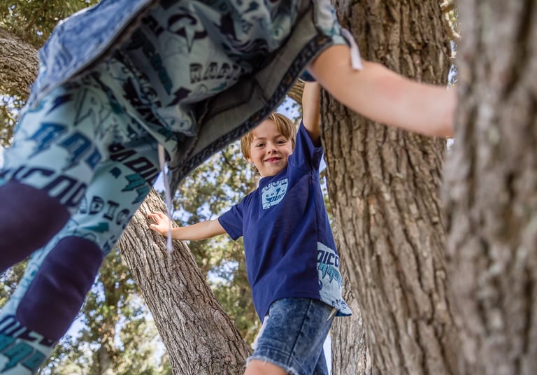 Fashion photography - two boys playing in a tree