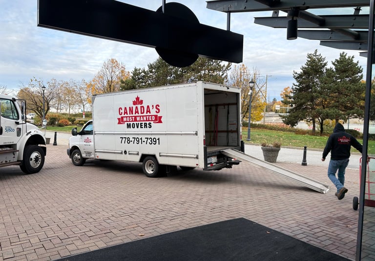 Canada’s Most Wanted Movers unloading at a commercial property in Coquitlam with ramp extended.