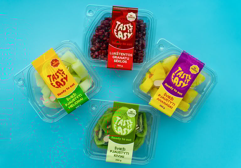 mėlyname fone padėti pjaustytų ananasų, melionų, kivių bei lukštentų granatų indeliai