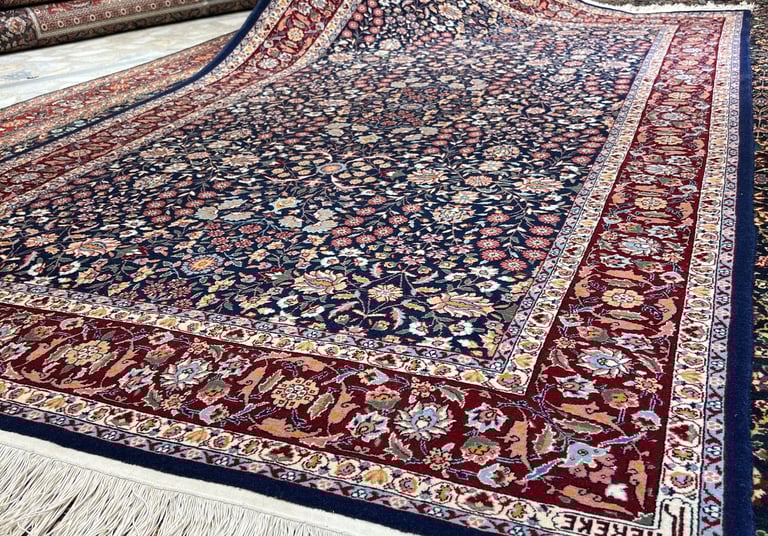 a man is holding a large rug in a room