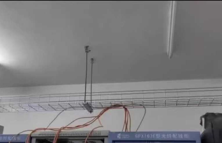 a line of wire mesh cable tray are hanging from the ceiling