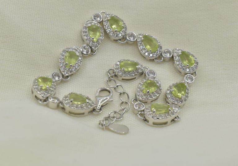 Elegant silver bracelet featuring teardrop-shaped green peridot gemstones and sparkling cz accents.