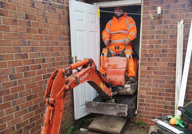 Digger operator preparing foundation for new extension in Stourbridge