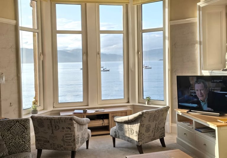 The living room at Gourock Seaview Holiday Let with a large window with sea views and a television