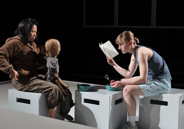 Jordan Palmer, actor and physical comedian, reads a book to a weathered puppet during performance