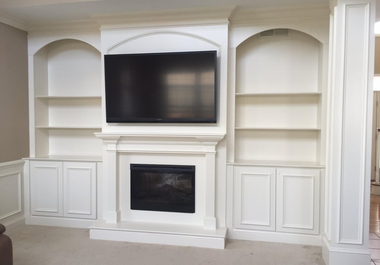Custom white fireplace wall unit with built-in bookcases and lower cabinets in Monmouth County NJ