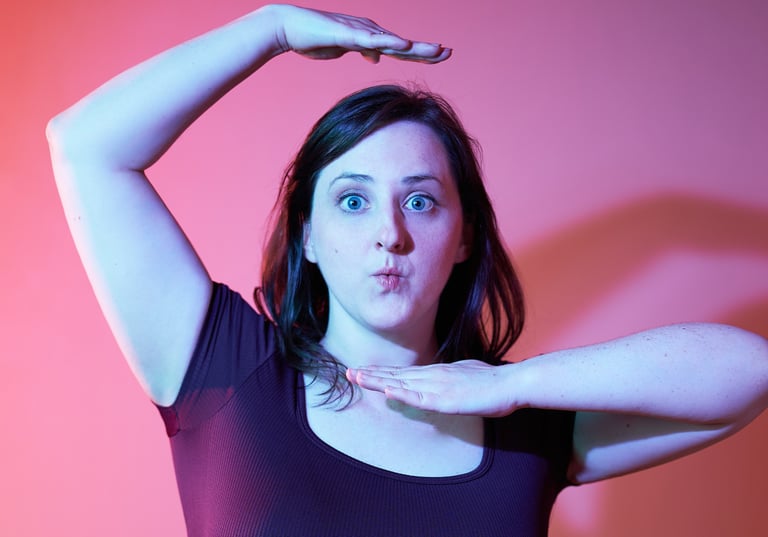 a woman with a fun expression and posture with pink background