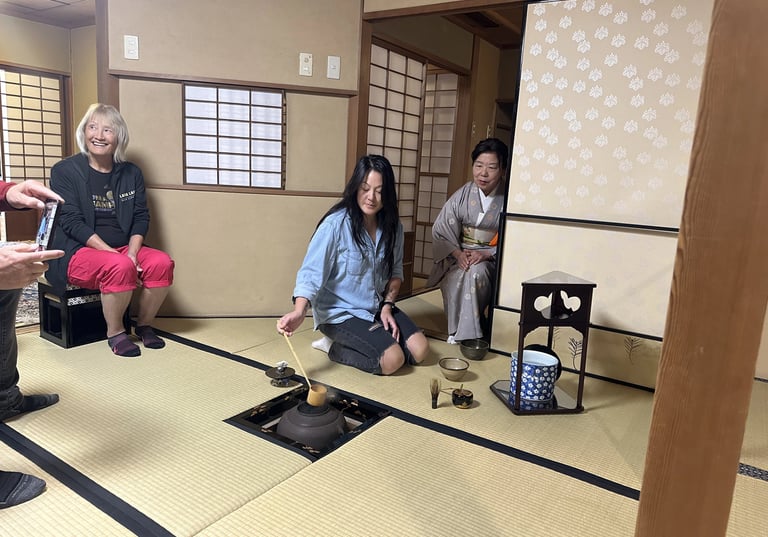 A young woman in a traditional tea ceremony, preparing matcha in a calm tatami room.