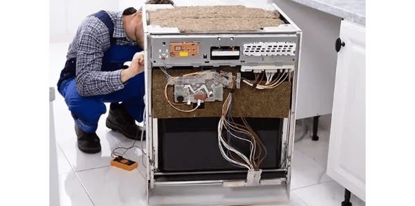 a technician repairing a dishwasher front panel is removed